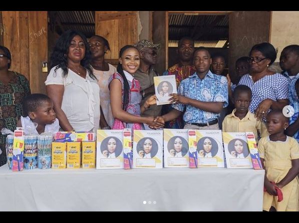 Akuapem Poloo donating note-books to the students.