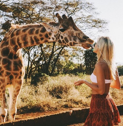 Lauren Bullen kissing Giraffe during a trip to Africa