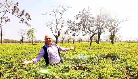 Harshvardhan Jain in a field of plants and trees in Assam