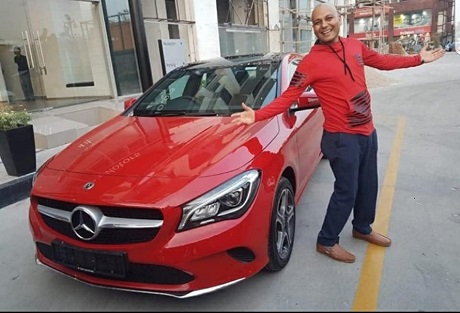 Harshvardhan Jain with his brand new red Mercedes