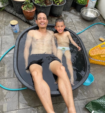 Mark Wiens enjoying with his son Micah Wiens in a small pool in Bangkok