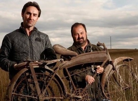 Frank Fritz and Mike Wolfe posing with an antique bike