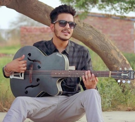 Rachit Rojha attempting to play guitar