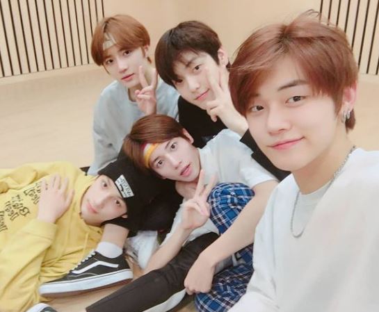 Huening Kai with TXT group members