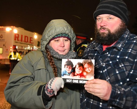 Edward Lake and his wife holding the picture of their three kids